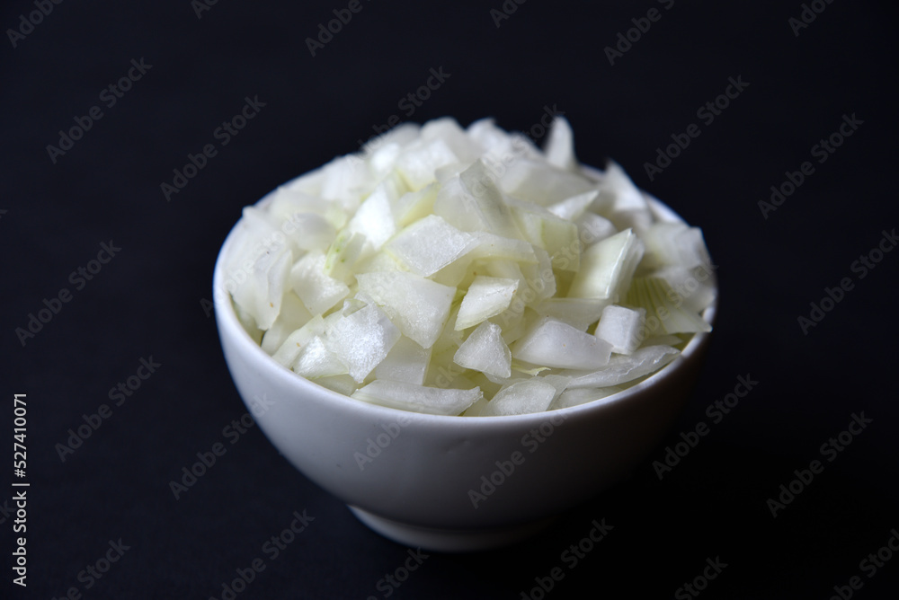 Juicy onion in a white plate on a black background. Delicious sliced onion in a bowl. Juicy onion in a white plate on a black background. Delicious sliced onion in a bowl.