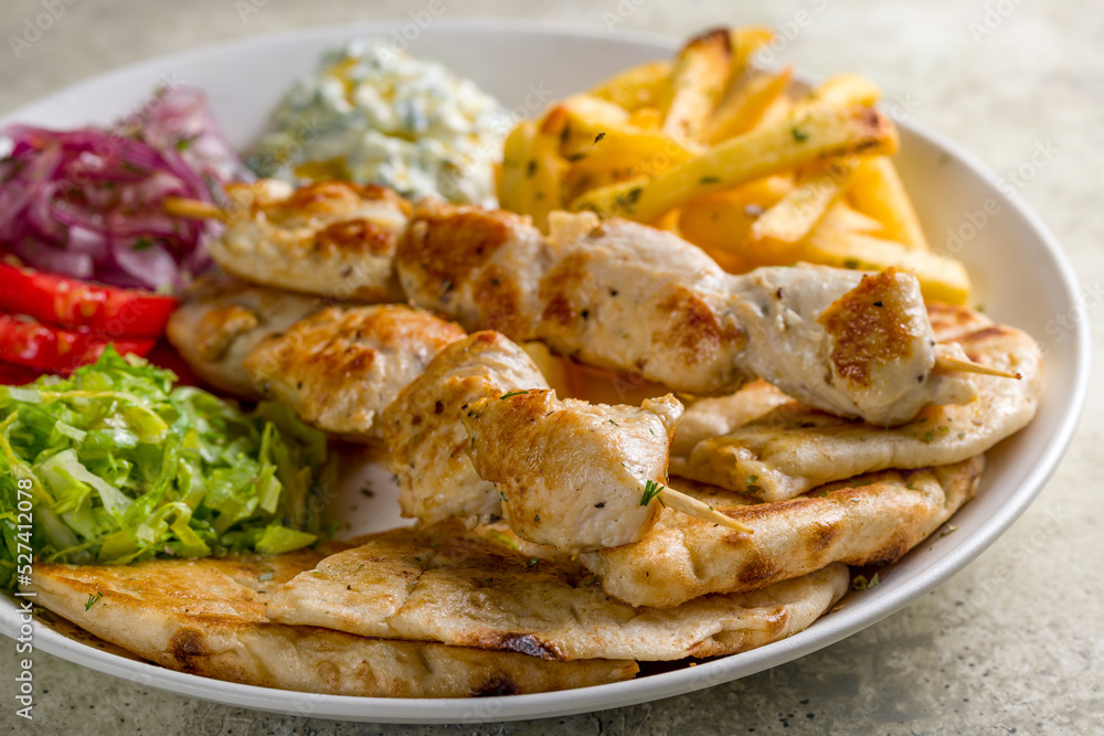 souvlaki with chicken and pita on white plate, Greek cuisine macro close up