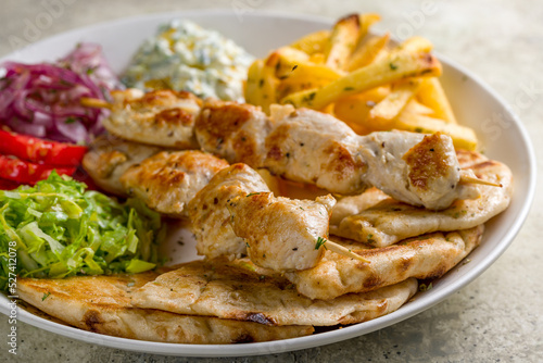 souvlaki with chicken and pita on white plate, Greek cuisine macro close up