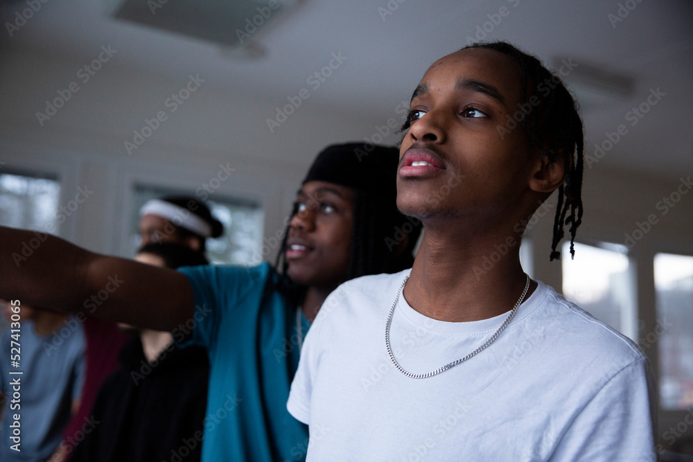Curious male friends looking away in games room Curious male friends looking away in games room