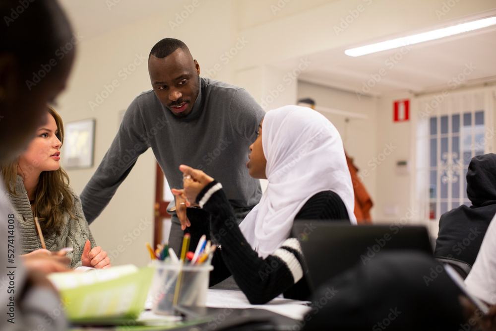 Students discussing with teacher in classroom Students discussing with teacher in classroom