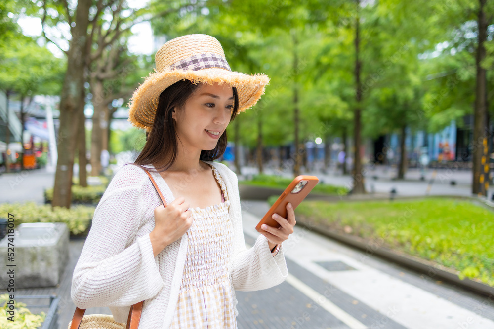 Tourist woman use smart phone in Xinyi district in Taipei city of Taiwan