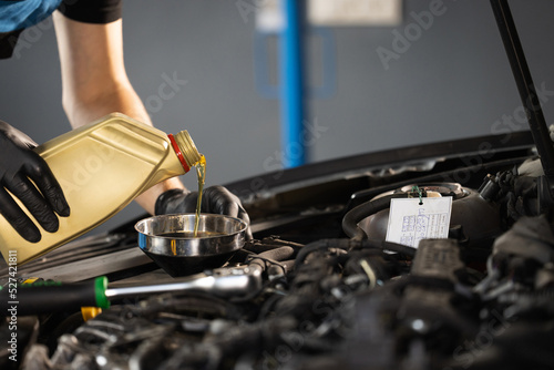Close up of pouring fresh new motor oil into car\'s engine. New engine oil is poured into the engine. replacement of technical fluids of the car