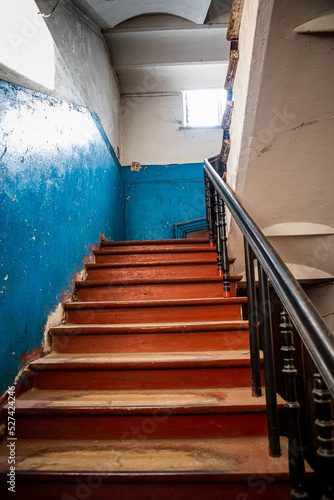 A vintage wooden staircase between the floors of an obsolete building