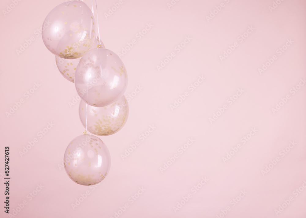 A monochromatic pink confetti clear balloons against a light pink backdrop A monochromatic pink confetti clear balloons against a light pink backdrop