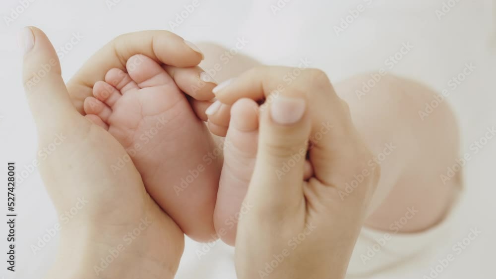 Baby feet in mother hands. Tiny newborn baby's feet on female heart shaped hands closeup. Mom and her child. Carefree healthy babyhood, healthcare and paediatrics care concept. Baby feet in mother hands. Tiny newborn baby's feet on female heart shaped hands closeup. Mom and her child. Carefree healthy babyhood, healthcare and paediatrics care concept.