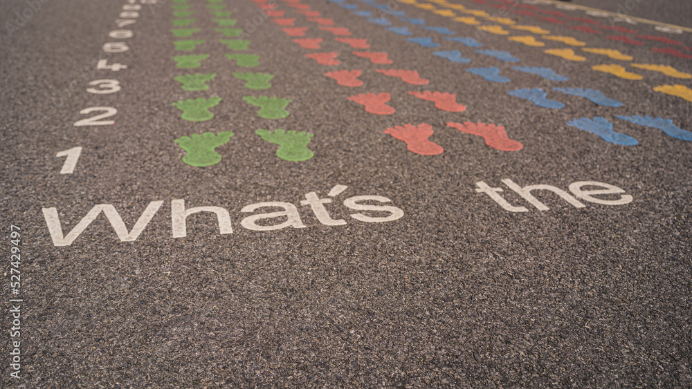 Obraz premium Back to school. Schoolyard on a sunny afternoon. A colorful game with feet and numbers on asphalt at the schoolyard playground. Pupils playing on the schoolyard.