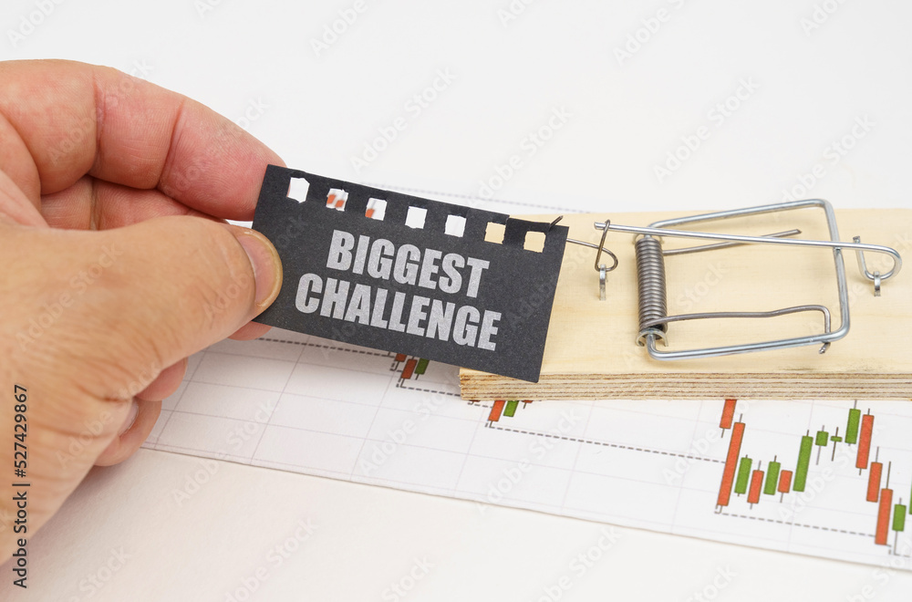 Fototapeta premium On the quote chart there is a mousetrap from which the hand takes out a sign with the inscription - Biggest Challenge