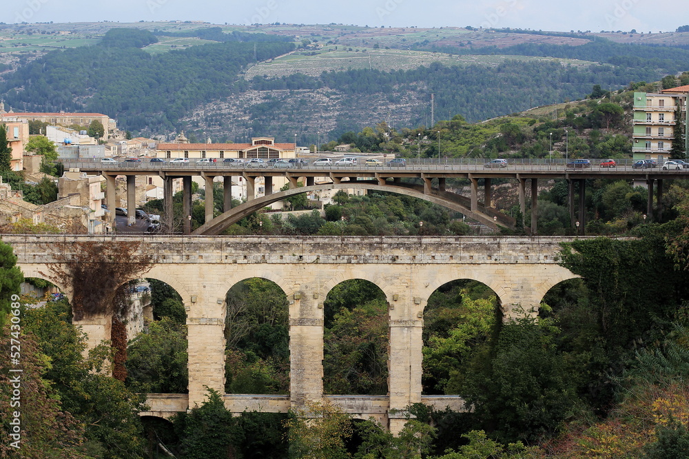 Fototapeta premium View of the two Ragusa / Sicily bridges, in the foreground the ancient Ponte Vecchio / Ponte dei Cappucini, in the background Ponte Papa Giovanni XXIII, the historic center of Ragusa.