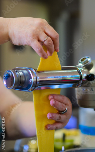 Cropped Hand Of Woman Making Pasta With Pasta Making Machine