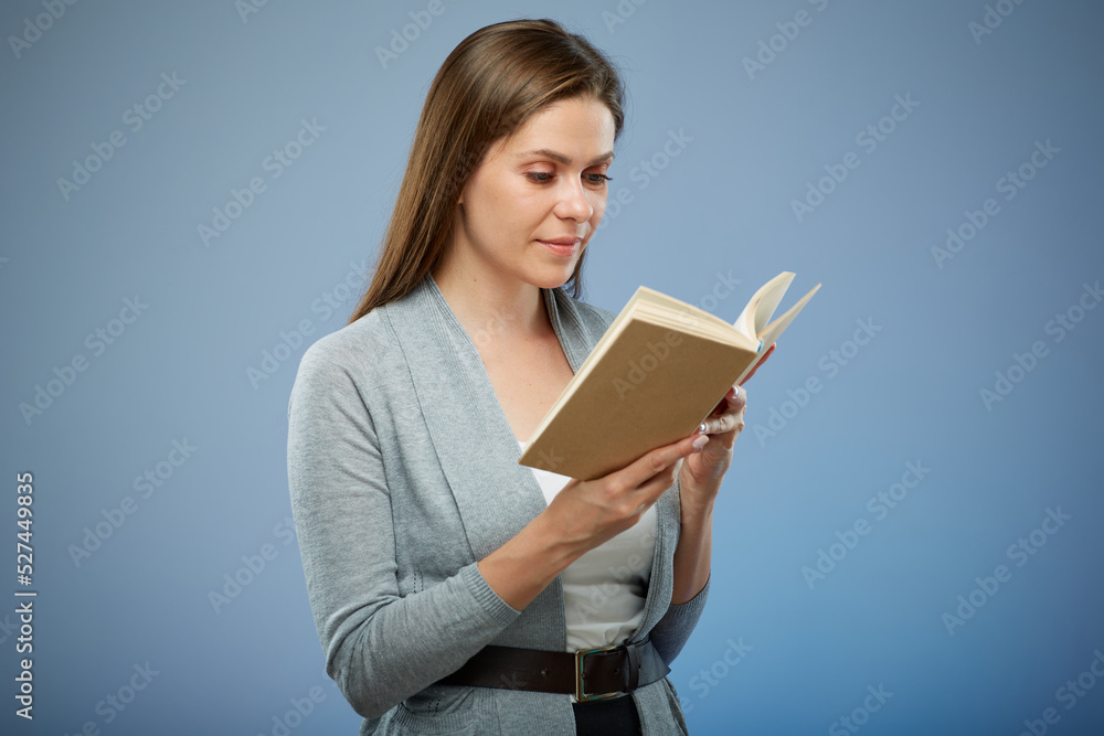 Smiling girl student or woman teacher reading book, portrait isolated on blue.. Smiling girl student or woman teacher reading book, portrait isolated on blue..