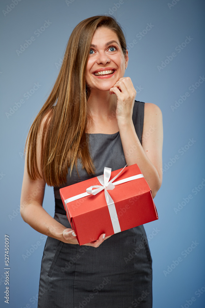 Smiling business woman with red gift box looking up studio isolated portrait on blue. Smiling business woman with red gift box looking up studio isolated portrait on blue.