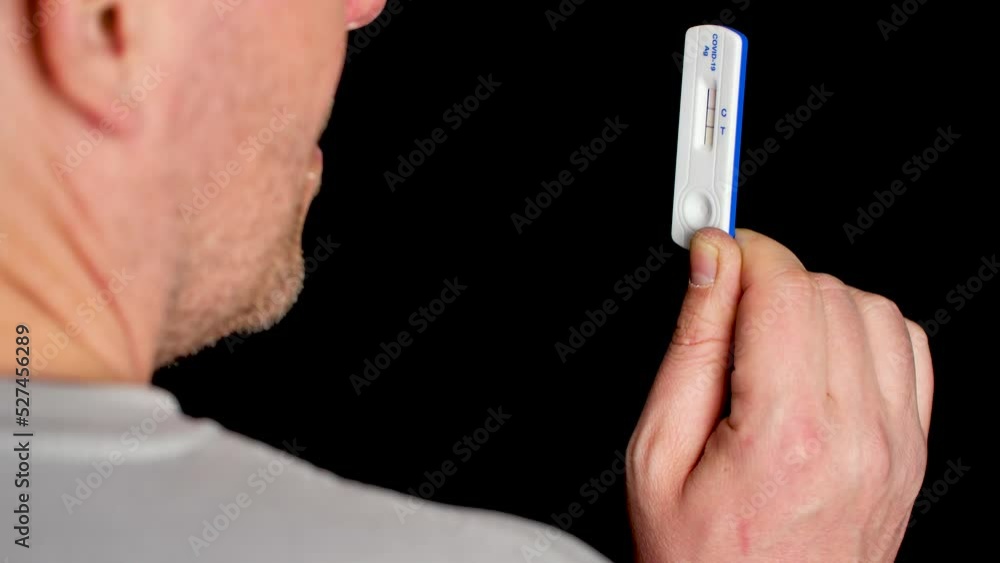 Close up of a man looking at covid-19 test. Concept, black background. Close up of a man looking at covid-19 test. Concept, black background.