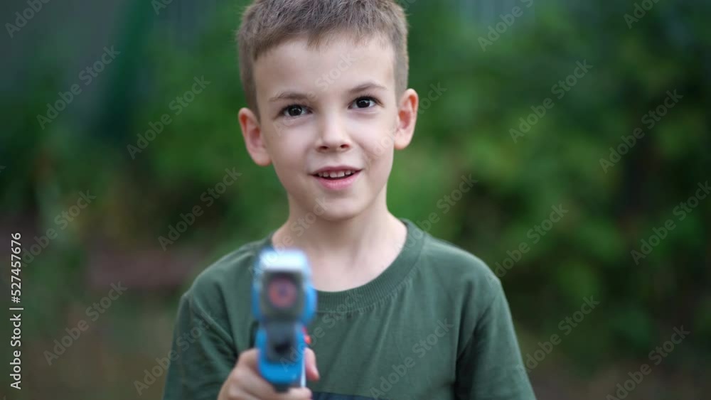 Portrait of a boy playing with a musical gun outdoors in the park Portrait of a boy playing with a musical gun outdoors in the park