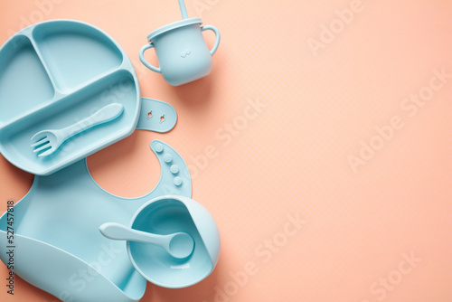 Silicone baby feeding set on color background. Flat lay, top view.