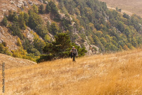 A tourist walks along the slope of the Demerdzhi mountain range
