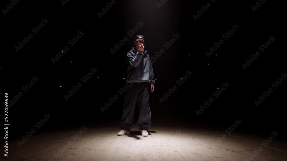 popping dance performance of young man in bright soffit light, street dance battle or talent show popping dance performance of young man in bright soffit light, street dance battle or talent show