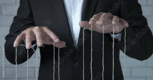 Strings attached fingers. A view of strings attached man's fingers. A concept of business manipulation in the office.