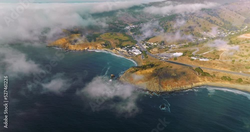 Beautiful rocky coast of sunny Montara State Beach from water. Fog moving on the land from the ocean. Top view. photo