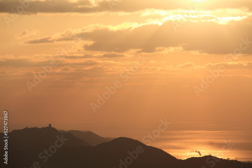 the sun rising from beyond the peninsula and horizon in the sea gives off a divine light