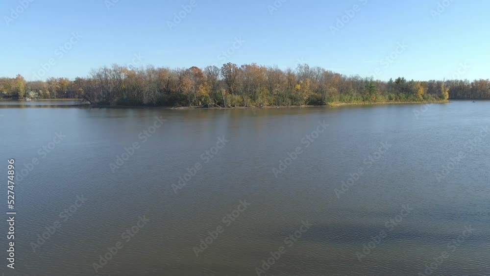 Aerial drone video panning very slowly from right to left over the calm water of the river in Rosemere with an island as point of interest in the Fall Aerial drone video panning very slowly from right to left over the calm water of the river in Rosemere with an island as point of interest in the Fall