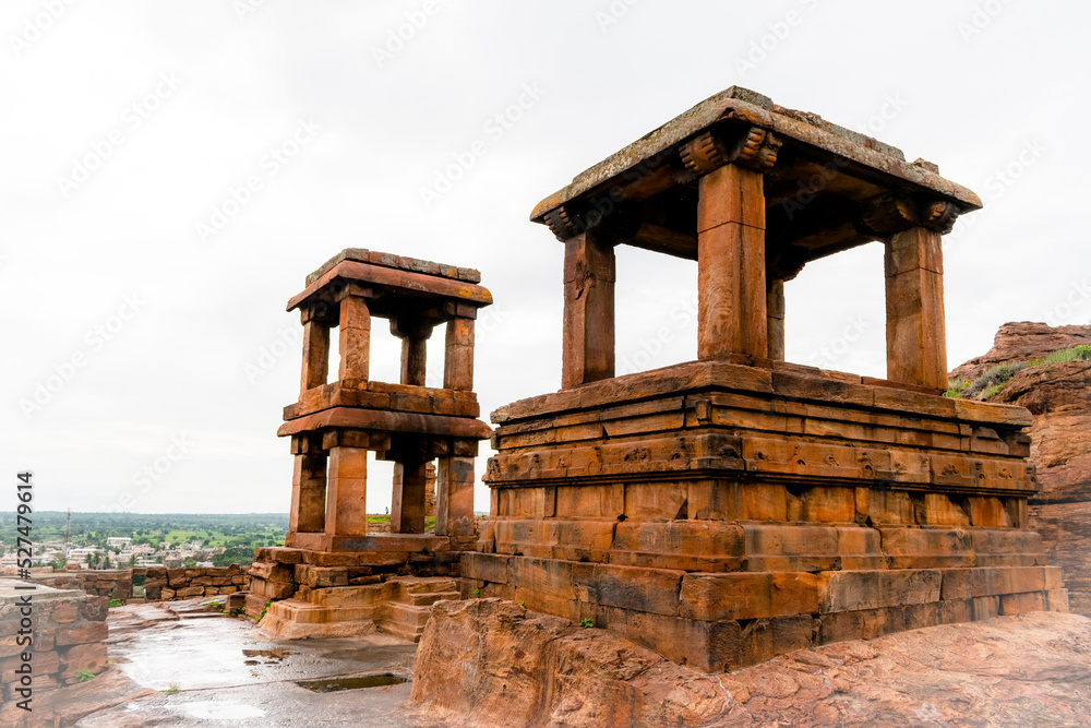 The remnants of pavilions(Open Mandapas) at Badami, perhaps once part of a Chalukya palace, are balanced on cliffs with temples in the distance, Karnataka,India