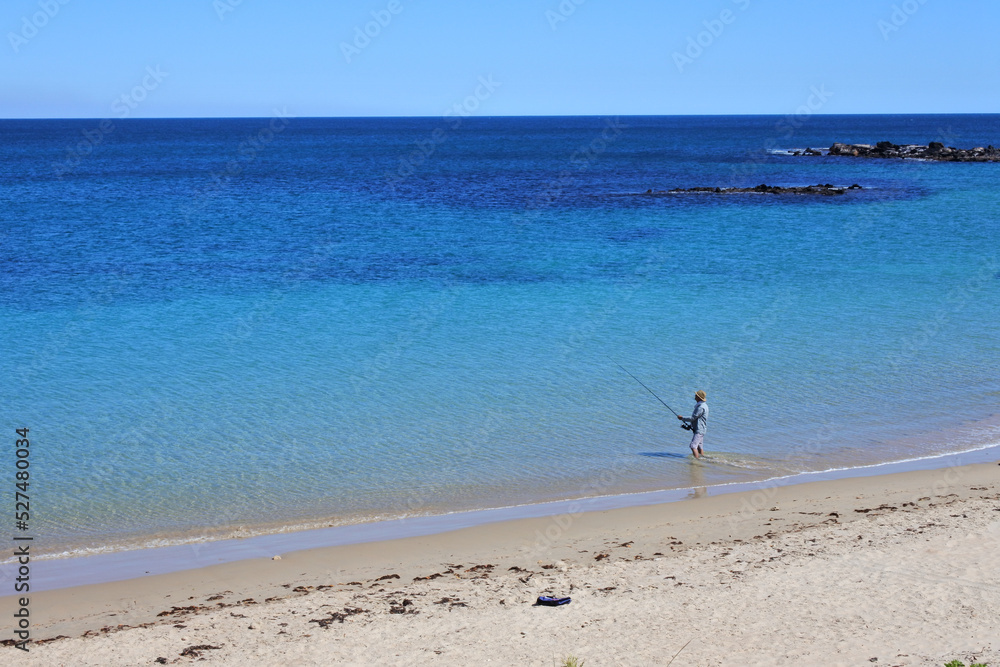 Fototapeta premium Australian man fishing on a remote beach