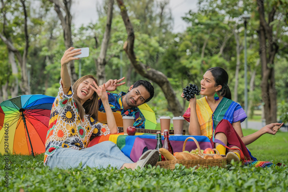 Obraz premium LGBTQ people friends enjoying picnic together in park and having selfie