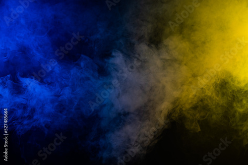 Yellow-blue smoke in neon light on black background. © Михаил Решетников
