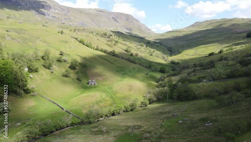 Sunny Drone View Of Kirkstone Pass  Area Valley Floor With Cloud Shadows On Fields Looking Up To Red Screes Fell With Old Farm Building photo