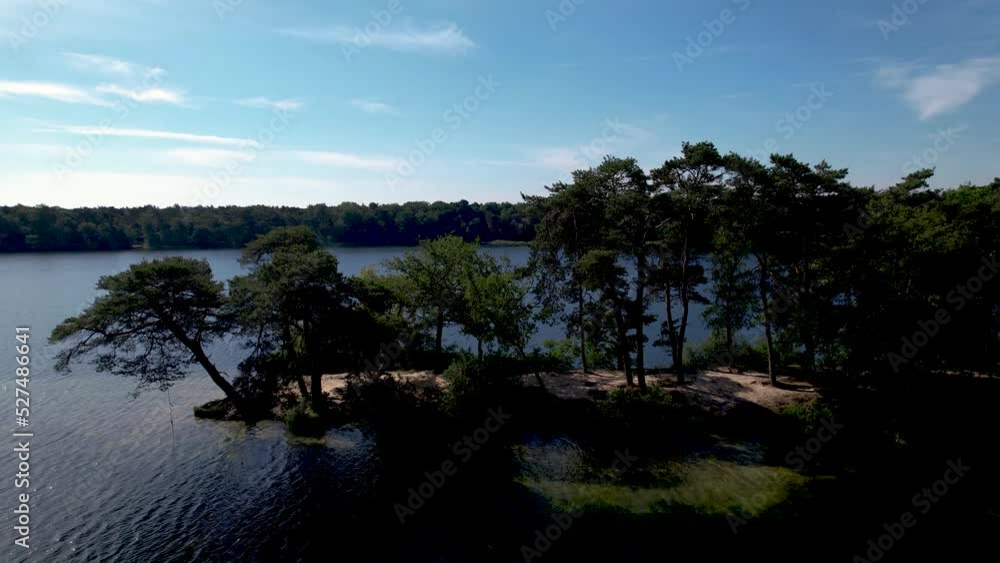 Aerial pan around tip of peninsula in Dutch landscape with long shadows of trees in countryside making a picturesque lake overview with woods Aerial pan around tip of peninsula in Dutch landscape with long shadows of trees in countryside making a picturesque lake overview with woods