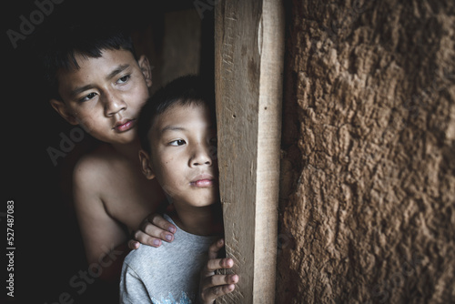 Two poor children Secretly beside the door, his eyes were sad and hopeless. The concept of human trafficking and fear of children, extreme poverty. photo