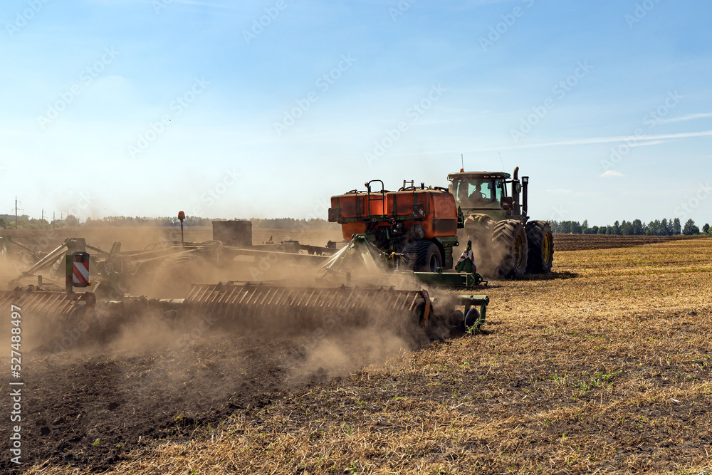 Fototapeta premium The tractor plows the land. Agriculture image.