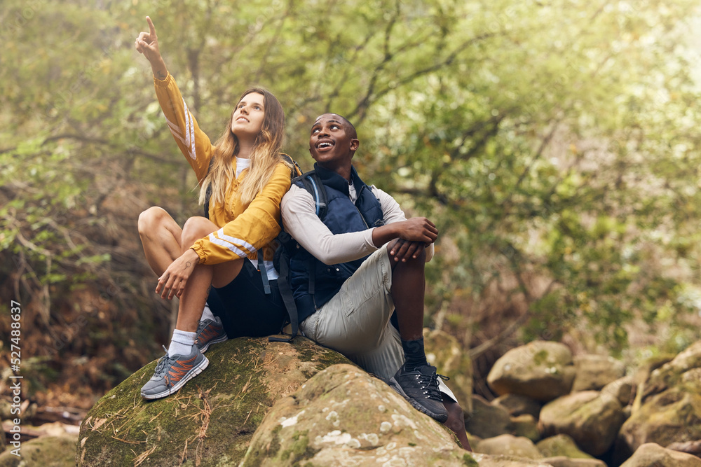 Fototapeta premium Hiking, freedom and couple relax on rock while looking at the nature, trees or calm sky outdoors. Relax and motivation with man and woman on sports, fitness and health and wellness mindset walk