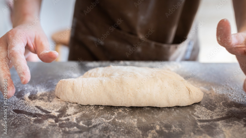 Obraz premium The process of making traditional French baguettes. Forming a blank from the dough. Front view.