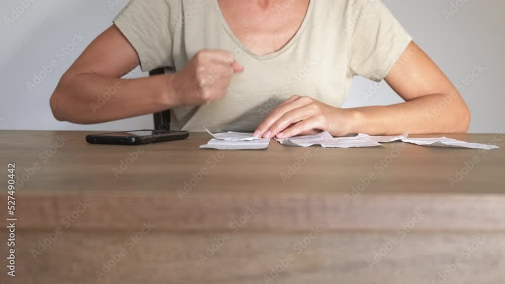 Female with energy crisis for household. A female count money for domestic energy on her telephone during energy inflation. Female with energy crisis for household. A female count money for domestic energy on her telephone during energy inflation.