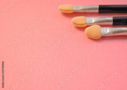 three brushes for makeup eye shadow on pink background. free space for text. Copy space