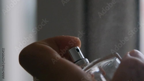 slow motion video, pressing of perfume button, spraying and spread of perfume at air.