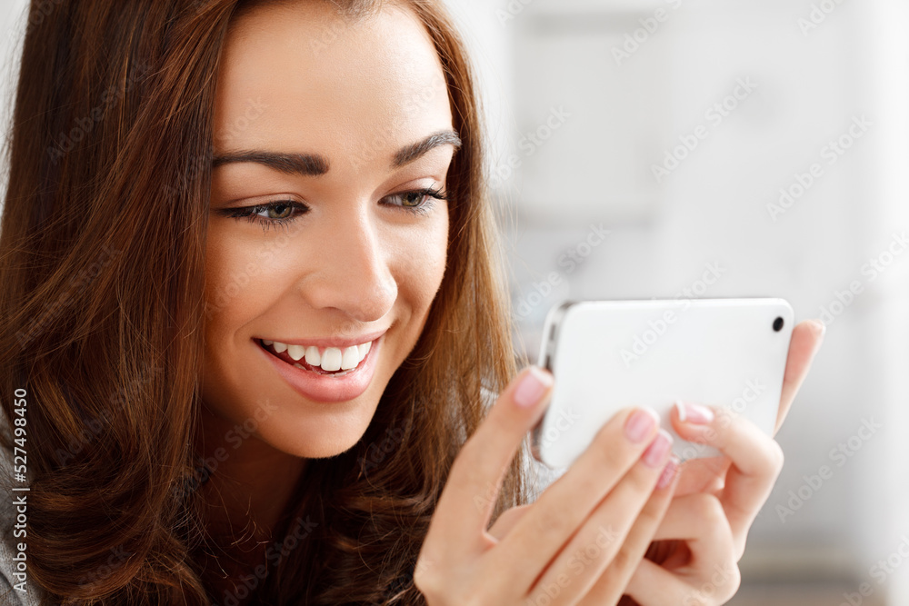 Happy woman watching videos with a phone with an internet app online to stream or download. Young lady smiling while reading a funny meme or enjoying a web series or movie with a smartphone at home Happy woman watching videos with a phone with an internet app online to stream or download. Young lady smiling while reading a funny meme or enjoying a web series or movie with a smartphone at home