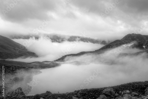 Shooting with focus stick. Black and white image. fog rises from the mountain valley and covers the mountain lake.