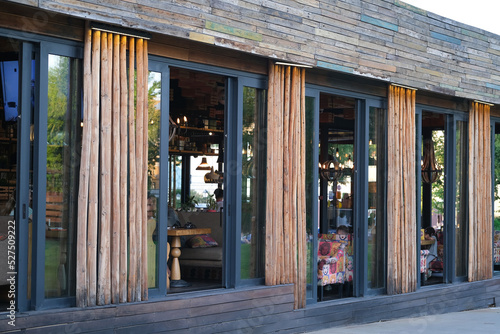 Exterior facade of restaurant with panoramic windows, with bamboo and wooden boards
