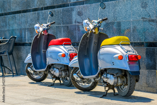 A vintage scooter - a retro moped is standing in the parking lot. Motor scooter ride. The concept of mobile transport in the city.