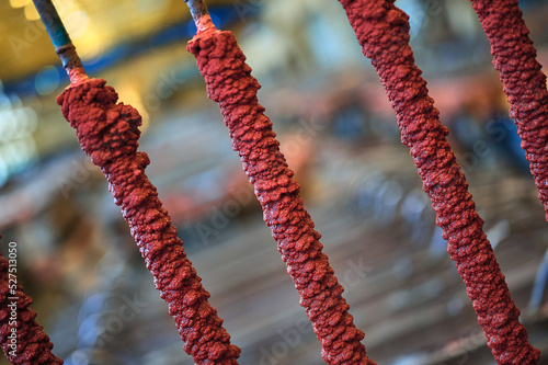 Red copper powder overgrowth on long metal cathode rods photo