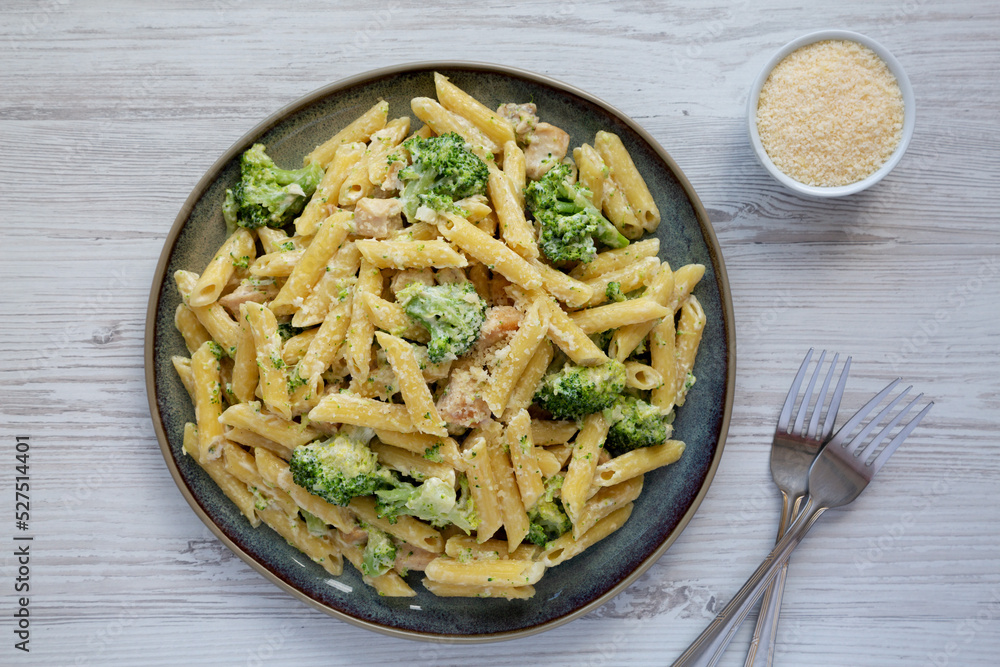 Homemade Penne Alfredo Pasta with Chicken and Broccoli on a Plate, top view. Flat lay, overhead, from above. Homemade Penne Alfredo Pasta with Chicken and Broccoli on a Plate, top view. Flat lay, overhead, from above.