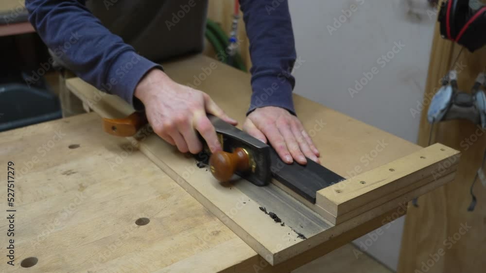 Craftsman Using A Wood Plane On A Piece Of Ebony Wood To Create New Items Craftsman Using A Wood Plane On A Piece Of Ebony Wood To Create New Items