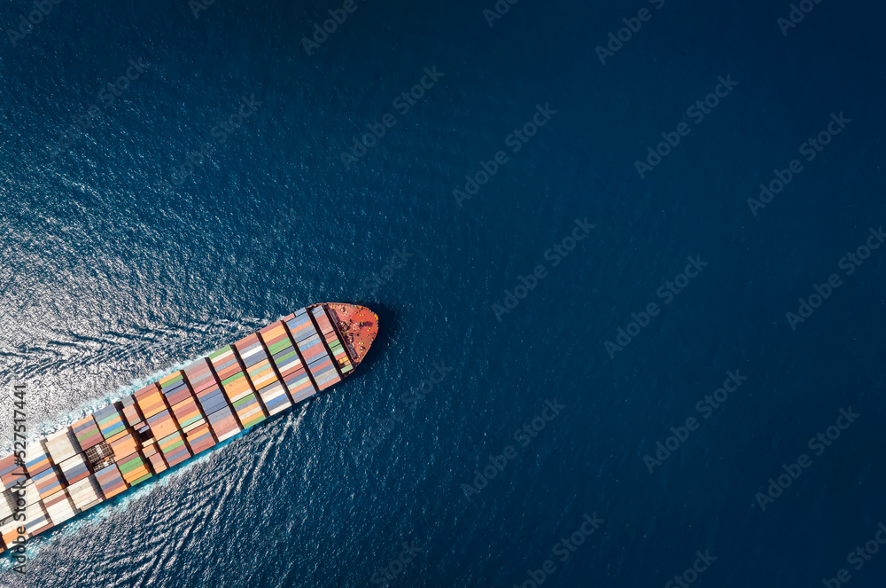 High aerial top down view of a large container cargo ship in motion over open ocean with copy space as a concept for import and export industry
