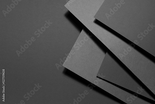Carbon grey abstract geometric background with fly rectangle stepped surfaces with corners in hard light, shadows in rich minimal business style for card, poster, flyer, text, top view, copy space.