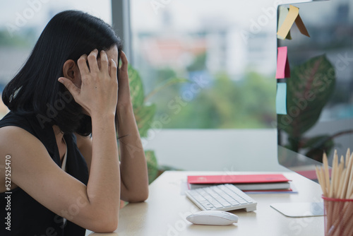 Asian business woman headache stressed because of work mistake problems about profit losses to be risk for fired from her job