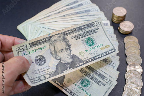 hand counting 20 dollar bills and coins