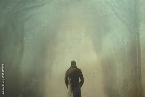 man from behind walks towards the light that leads him out of the woods